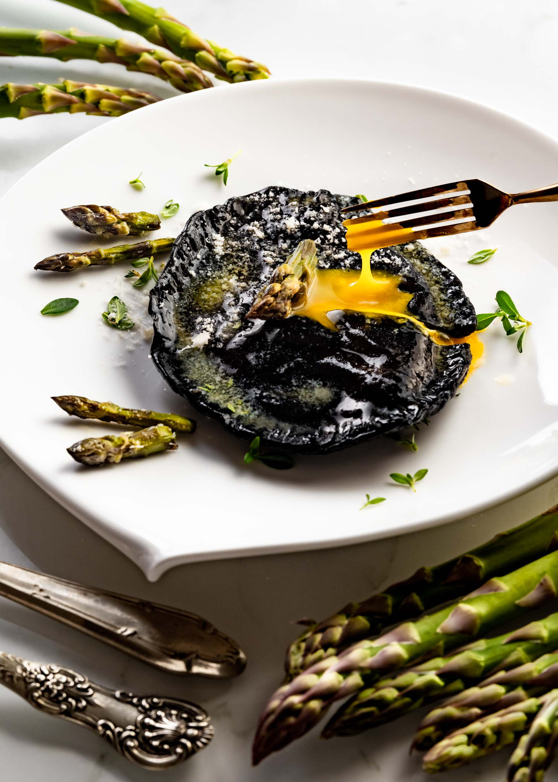 Raviolone ripieno di uovo con crema di parmigiano e asparagi